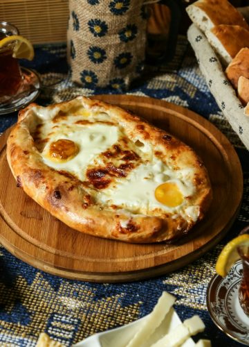 georgian khachapuri on the wooden board egg cheese buns tea side view