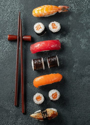 Set of sushi and maki on stone table.